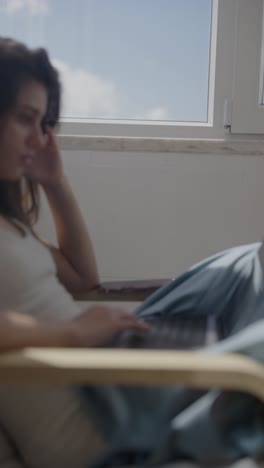 mujer trabajando en una computadora portátil en casa