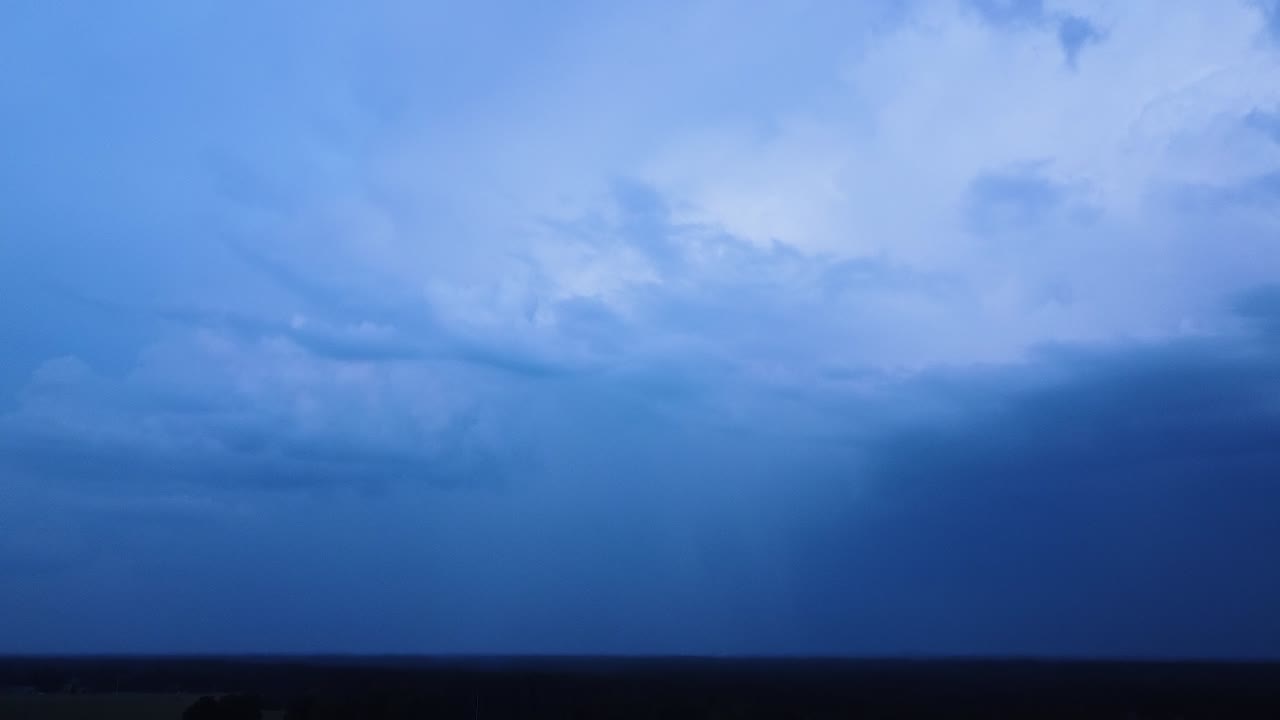 여름 저녁에 극적인 어두운 천둥 폭풍 구름의 아름다운 공중 전망, 구름을 통해 극적인 번개가 번쩍이는 극심한 뇌우, 먼 광각 드론 틸트 업 샷