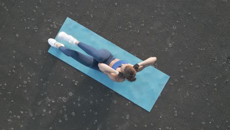 top-down view of a fit woman doing cross-body crunches