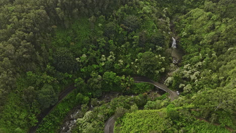 Maui-Hawaii-Aerial-v37-birds-eye-view-drone-flyover-Haipua'ena-Falls-along-Hana-highway,-elevation-up-capturing-lush-rainforest-landscape-with-misty-clouds---Shot-with-Mavic-3-Cine---December-2022