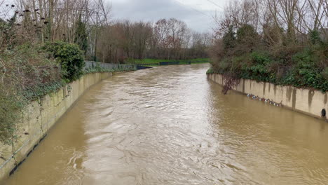 niveles extremadamente altos de agua se precipitan en un torrente a través de un canal de tormenta de hormigón artificial después de una sucesión de tormentas de lluvia muy fuertes