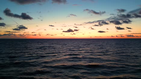 tropical golden sunset over ocean water slow motion aerial view