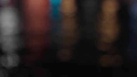 defocused colorful lights dancing on reflective water surface at night