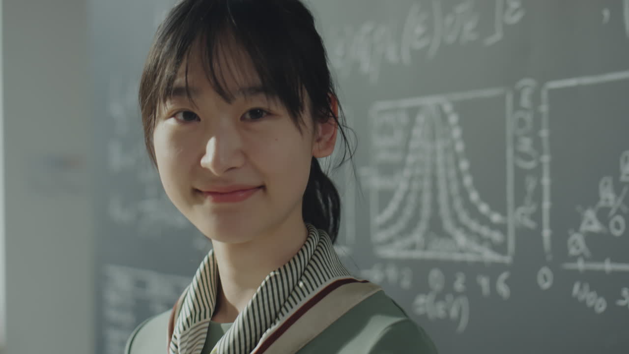 Smiling Young Woman in Front of a Science Chalkboard
