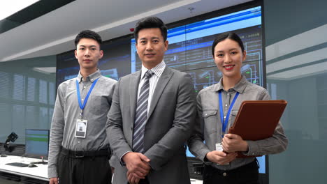 professional worker team group administrator in engine control server room among rows of rack server cabinets and using laptop to check its work