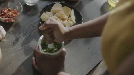 person grinding ingredients with a mortar and pestle for food preparation