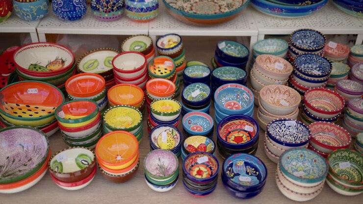 Valencia, Spain - May 21, 2025: Stacks of hand painted mini bowls neatly arranged on a stall table in soft daylight