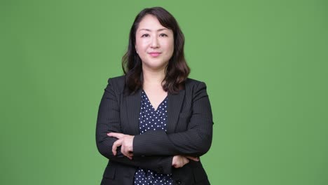 성숙하고 아름다운 아시아 사업가 여성이 팔을 고 있습니다.