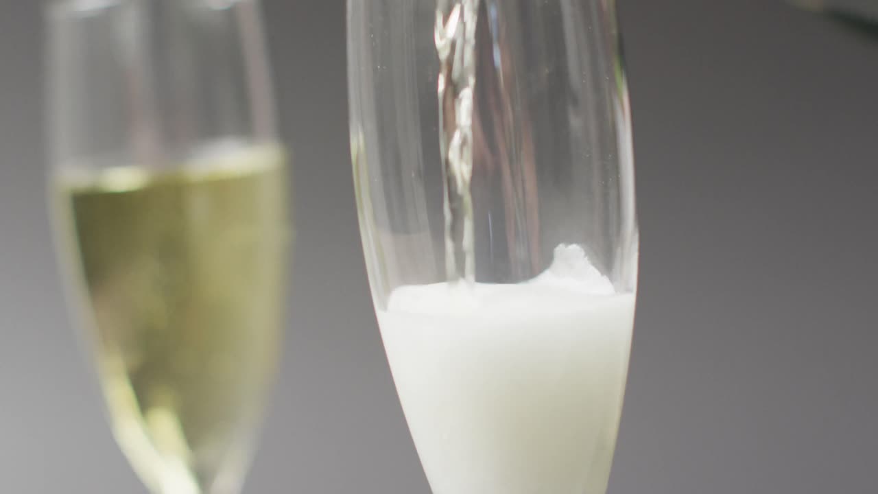 Video di champagne che viene versato in un bicchiere su sfondo grigio
