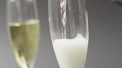 Video-Von-Champagner,-Der-Auf-Grauem-Hintergrund-In-Ein-Glas-Gegossen-Wird