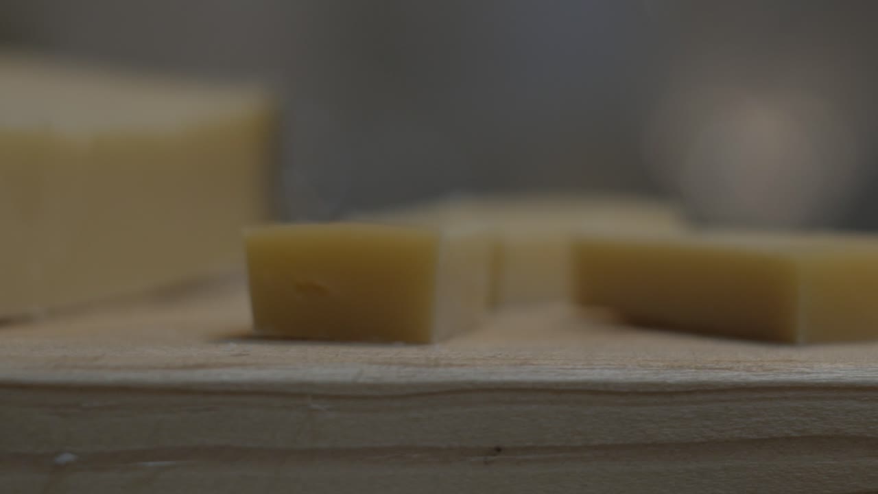 trozos de queso gouda girando sobre una mesa de madera, primer plano - portugal