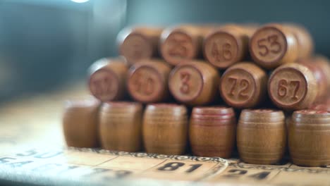 cinematográfico creativo suave soñador macro tiro de bingo barriles de madera en una fila, figuras de madera, viejos números de fondo, juego de mesa vintage, cámara lenta 120 fps video de gimbal comercial, movimiento de grúa