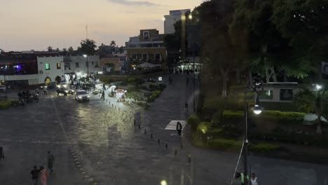 the center of the small town with a park and people as the sunset passes is hidden.