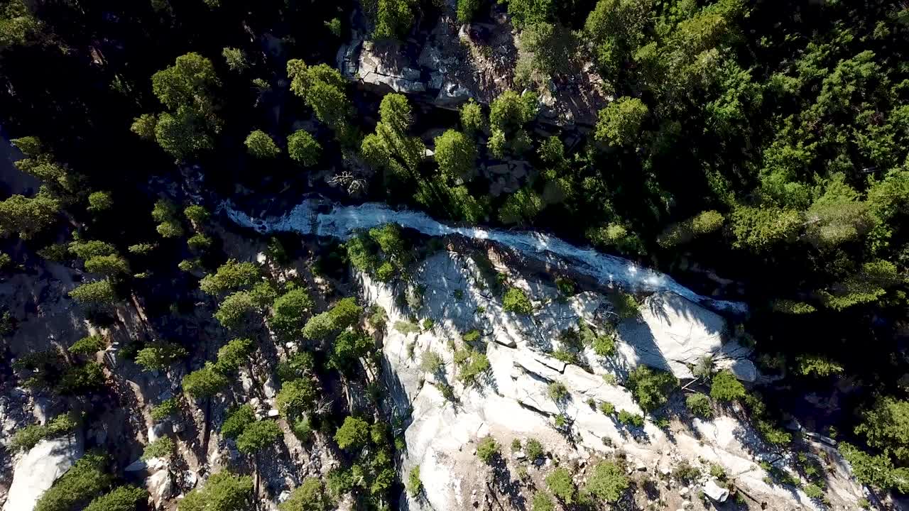 vista aérea de drones del agua de deshielo en un arroyo montañoso y cascada en un bosque siempre verde en el parque nacional sequoia, bajo el monte whitney, california, ee.uu.
