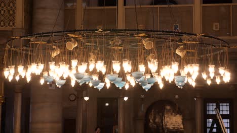 candelabro adornado con lámparas de vidrio azul en una mezquita
