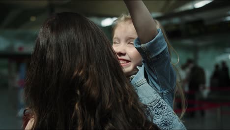 daughter rushes into mother's arms happy smiling in airport terminal. shot on red cinema camera in slow motion.
