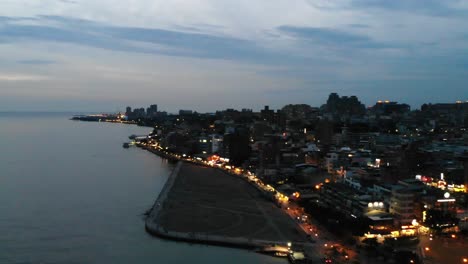 right aerial pan from river to city at dusk