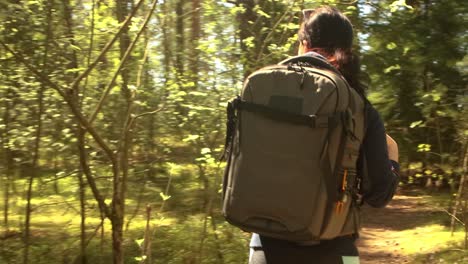 hiking woman walk with a hiking backpack in spring green forest