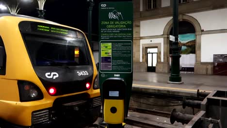 ticket scanner machine at sao bento station in front of train, porto