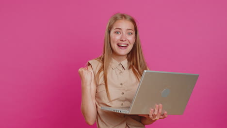Overjoyed-young-woman-working-on-laptop-celebrate-success-win-money-in-lottery-get-online-good-news