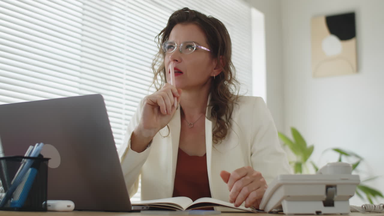 Caucasian Businesswoman Making Notes at Office Desk