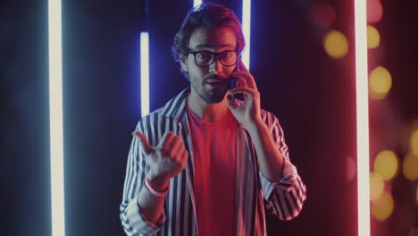 man talking on phone in neon lights