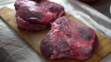 man salting a tasty piece of meat on the kitchen counter