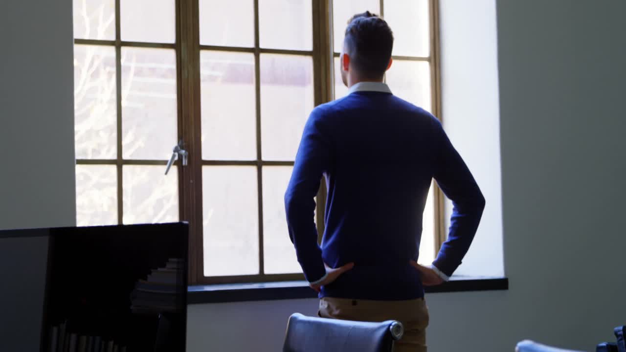 Executive looking through window in office 4k