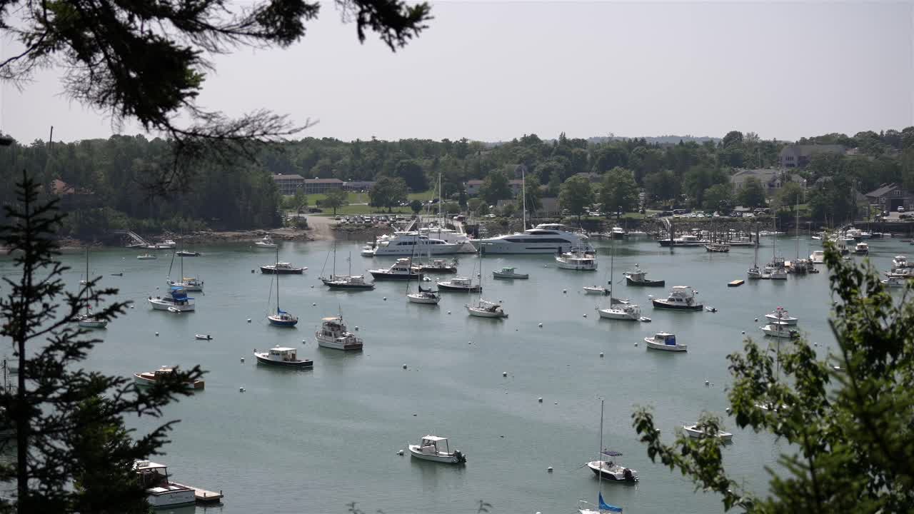 High angle static overview of boats and yachts anchored off shore from pier in marina