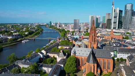 4k aerial drone video of the kaiserdom st. bartholomäus church on the banks of the main river in downtown frankfurt, germany