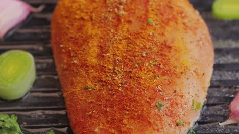 cooking raw chicken meat in yellow turmeric spice with garlic and greens on grill close-up. preparing raw food for cooking. grilled chicken, duck, turkey kebab with vegetables.
