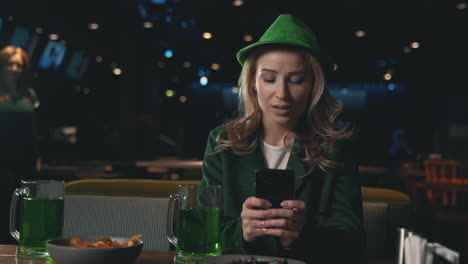 female friends in irish hats celebrating saint patrick's day in a pub