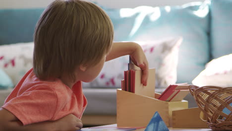 montessori school pupil working at desk with wooden shapes