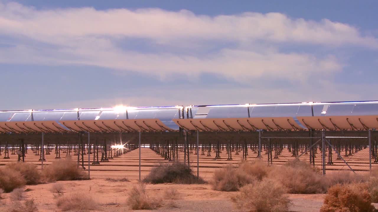 pan a través de una granja solar en el desierto genera electricidad