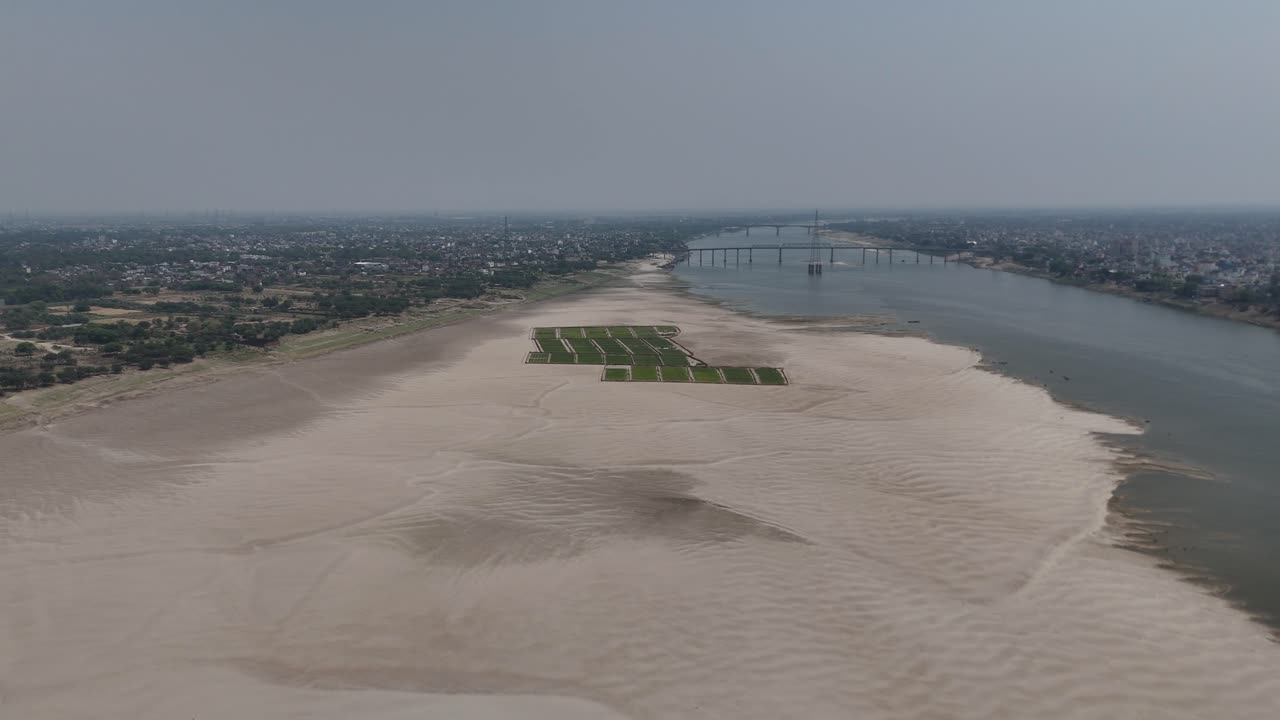High-angle view of Varanasi's riverbanks, where boats float gently on the sacred Ganges, and the air is filled with the sound of ringing temple bells and chants.