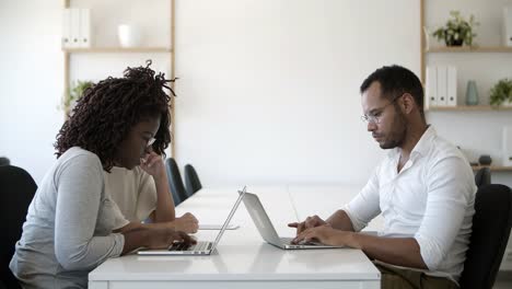 Gruppe-Von-Menschen,-Die-Mit-Laptops-Am-Tisch-Sitzen