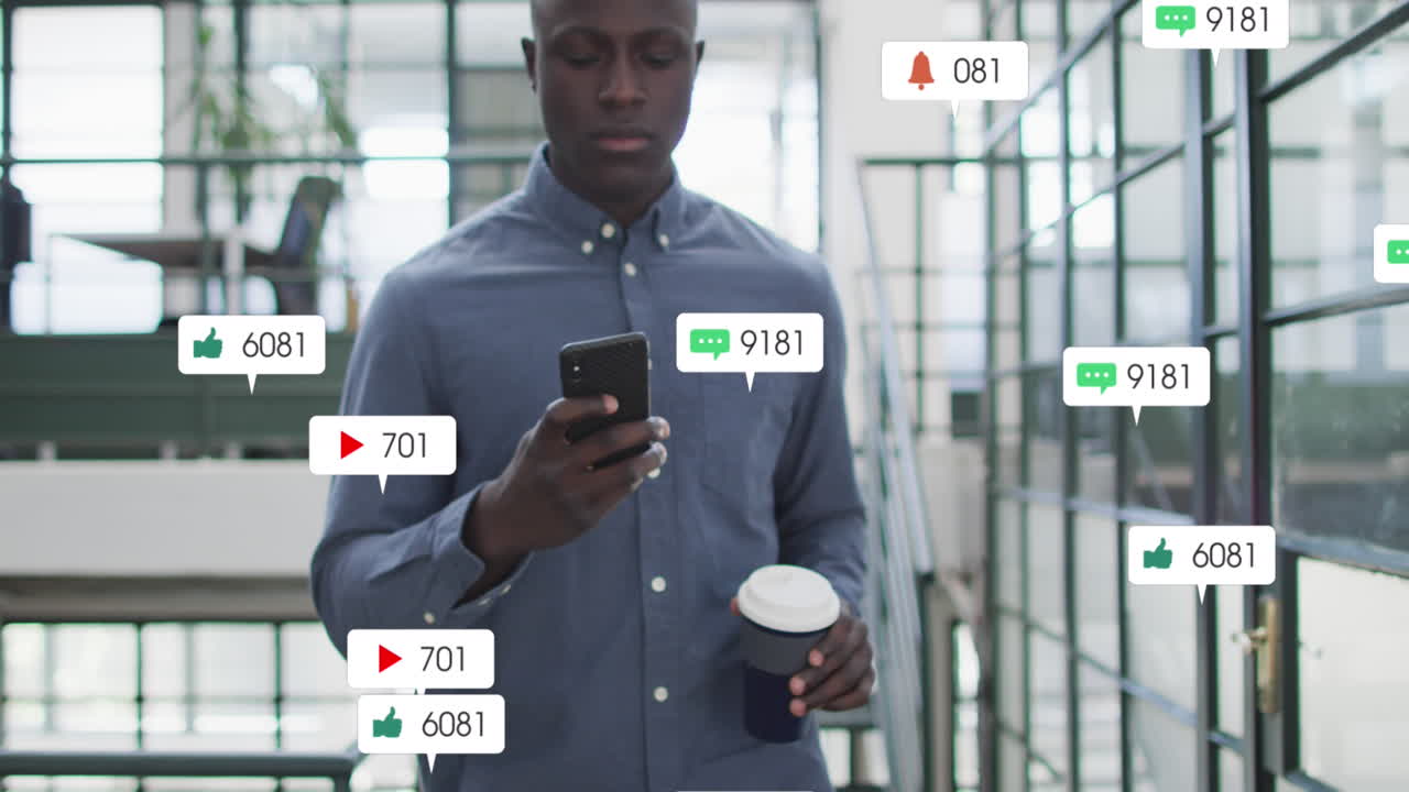 Animation of social media icons on african american man drinking coffee using smartphone at office