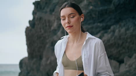 Chica-Disfruta-De-Auriculares-De-Música-En-La-Playa-De-Cerca.-Mujer-Escuchando-Canciones-Verticalmente