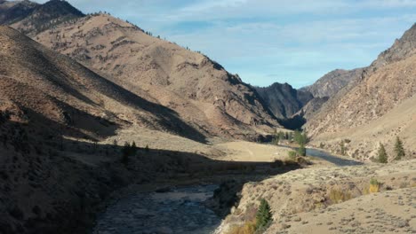 drone footage of an empty remote landing strip surrounded by mouintains near a river in the frank church river of no return wilderness in idaho