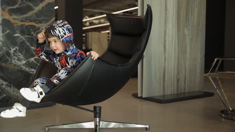 a young boy sitting in a modern chair