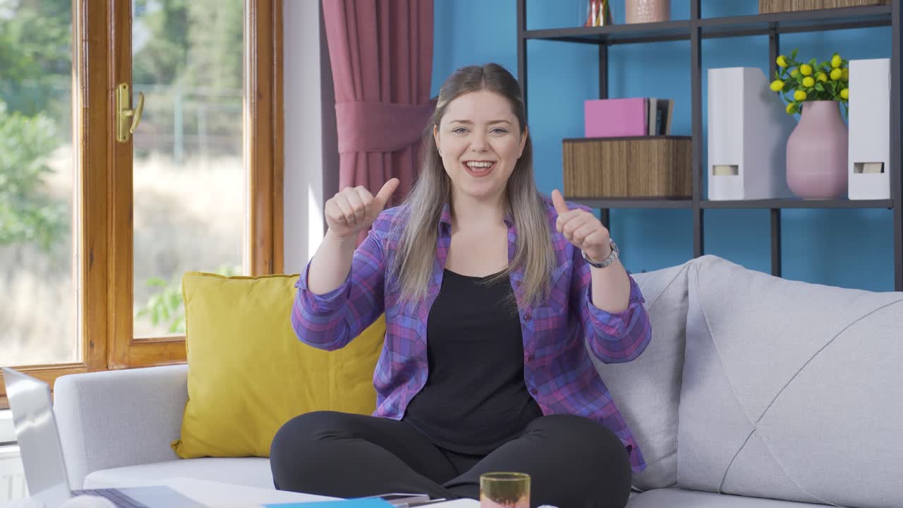 젊은 여성이 카메라에 축하 메시지를 보내며 박수를 치고 있습니다.