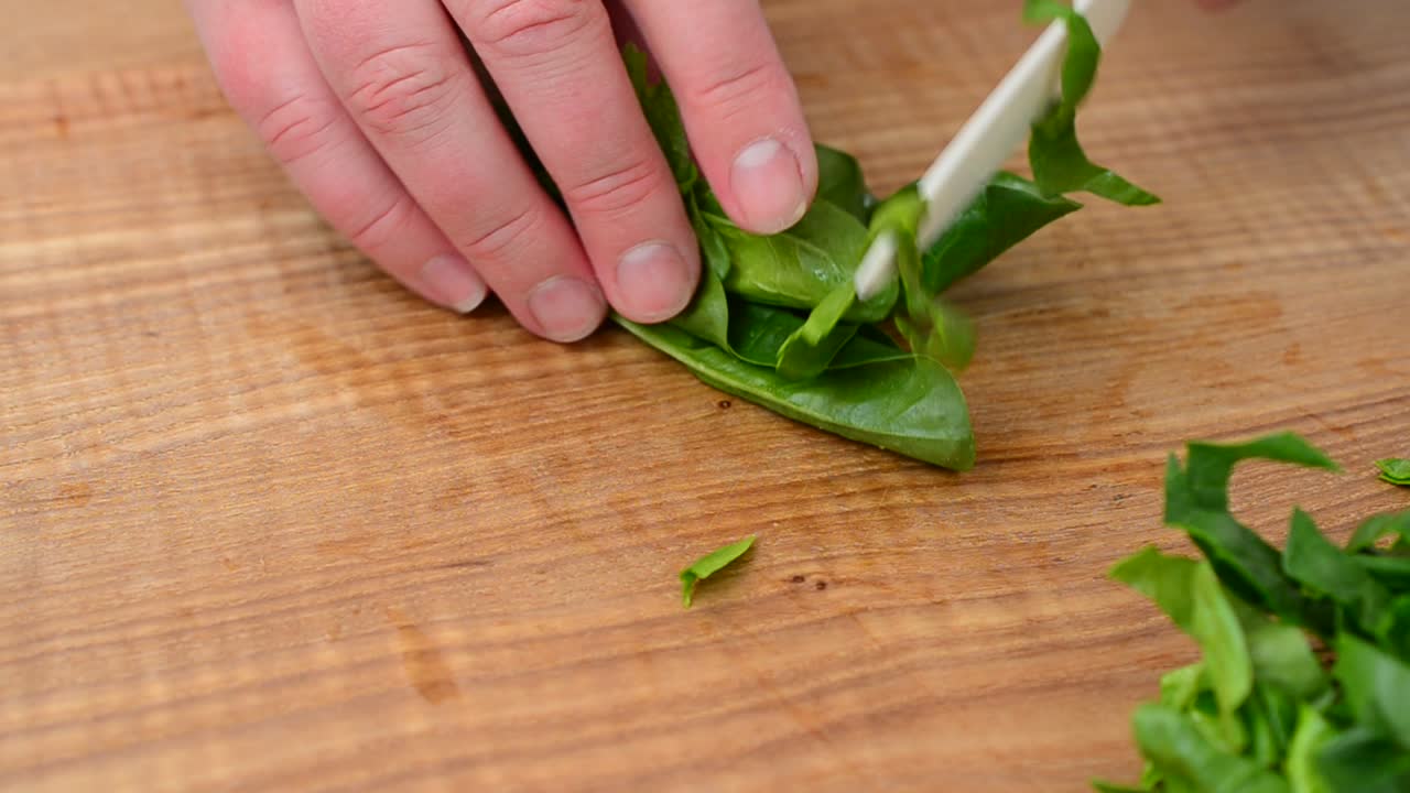 Foglie di spinaci su un tagliere. Riprese in movimento.