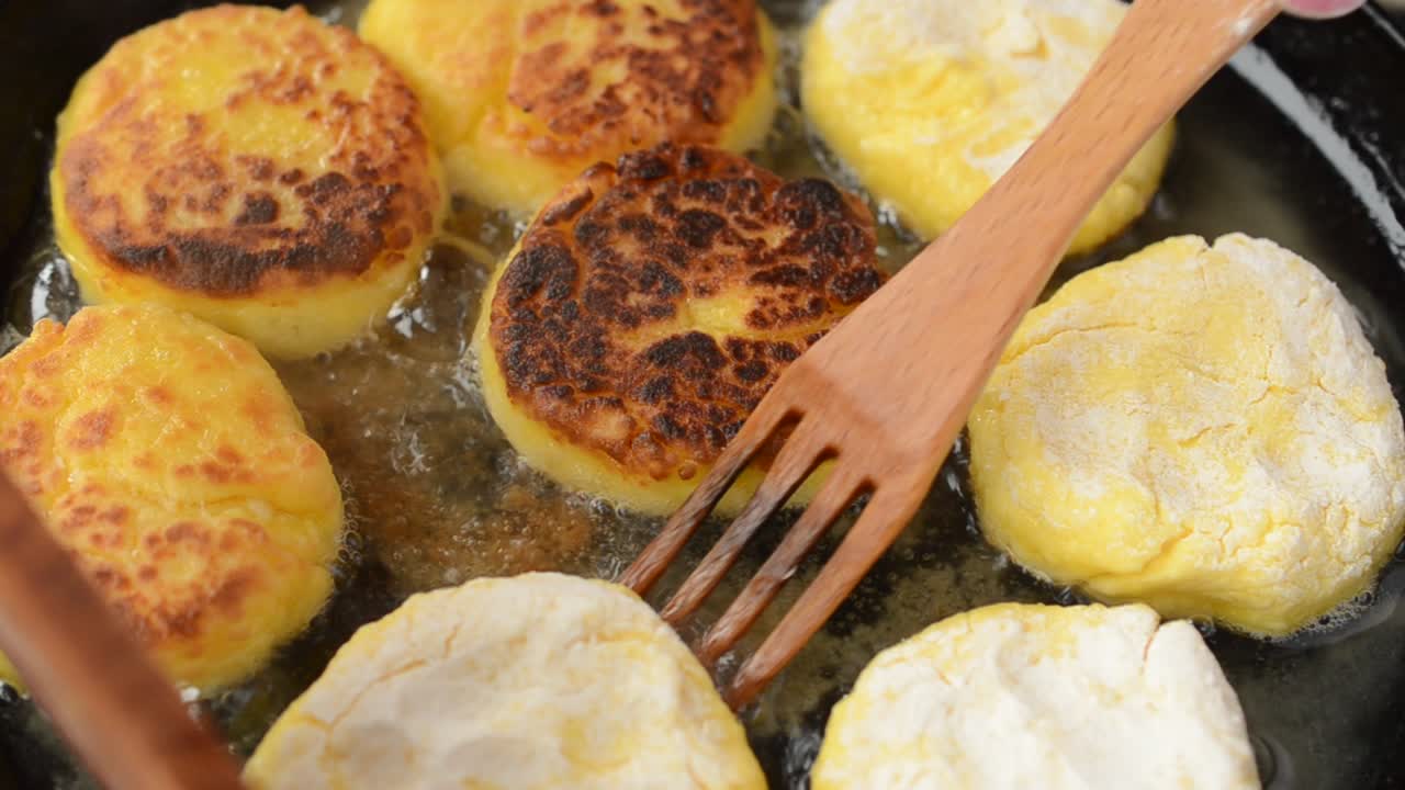 Kami menggoreng kue keju di wajan. Wajan besi cor. Kami memasak kue keju.