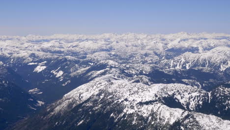 scenic snowy mountains and blue sky in winter - aerial shot