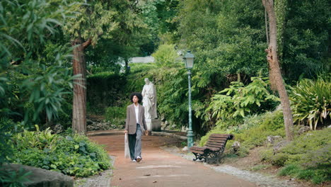 Woman-walking-city-park-alley-alone.-African-american-lady-enjoy-nature-greenery