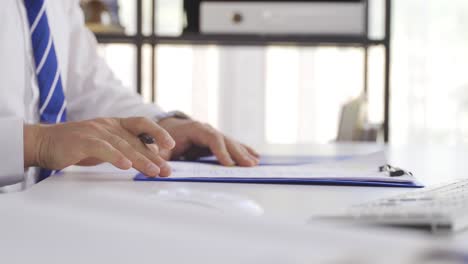 las manos de un hombre de negocios firmando papeles.