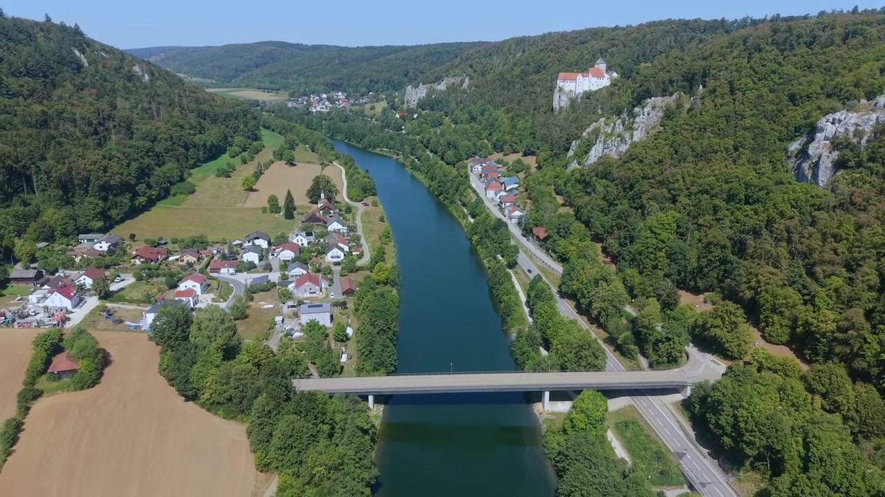 Betagende luftperspektiv af det middelalderlige Prunn Slot, der ligger på en klippe over Altmühl-floddalen og en moderne kanal i Bayern.