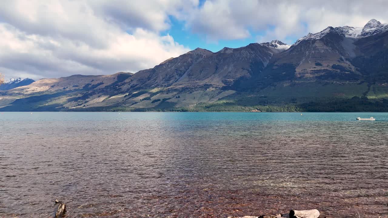 A tranquil scene of a lake with mountains in Glenorchy, New Zealand. Clear skies and calm waters create a peaceful atmosphere