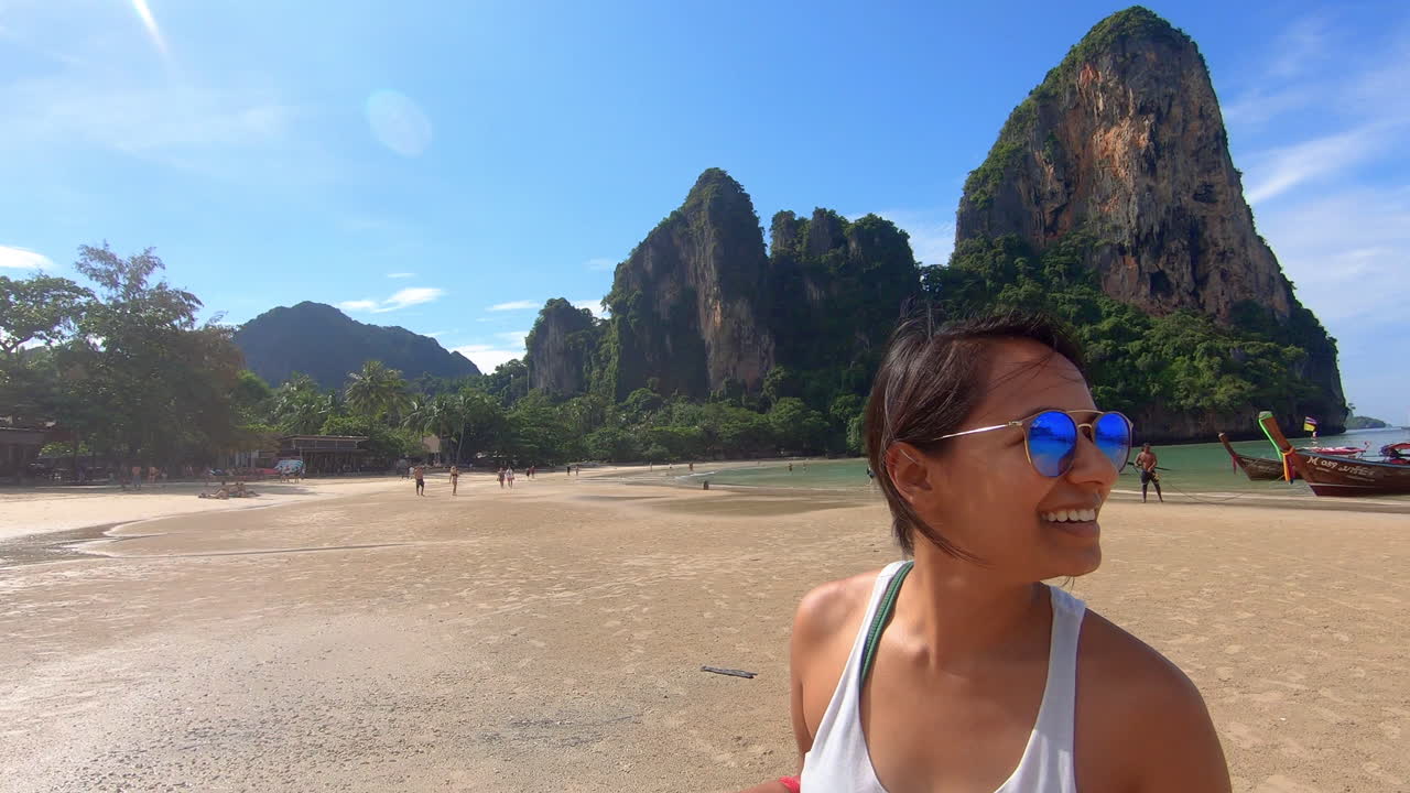 cámara lenta | primer plano - hermosa niña india en una playa en tailandia - sonriendo y disfrutando de la vista