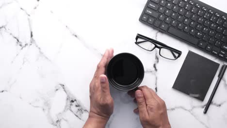 persona trabajando en un escritorio con una taza de café
